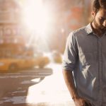 Digital composite of Business man standing against city background