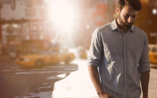 Digital composite of Business man standing against city background