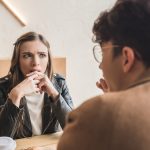 A young woman not looking interested while sitting on a date