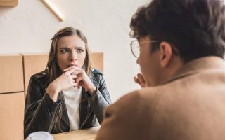 A young woman not looking interested while sitting on a date