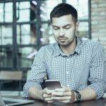 A man on his phone texting