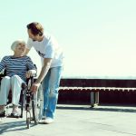 Volunteer helping an elderly patient in a wheelchair
