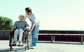 Volunteer helping an elderly patient in a wheelchair