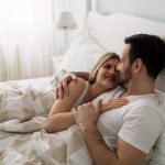 A happy couple in bed together