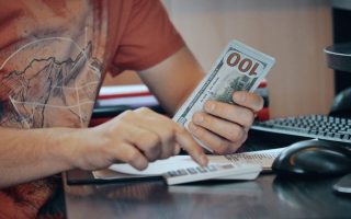 A man counting money. When you start making more money than people close to you, they can often feel betrayed
