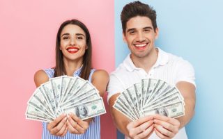 Excited young couple holding money