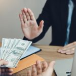 Businessperson refusing a stack of money