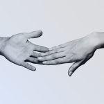 A pair of black and white hands reach out for each other