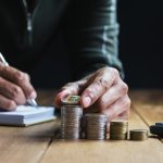 A man stacking his coins and protecting his money with financial boundaries