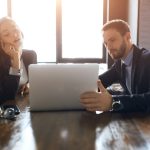 Two employees sharing a laptop
