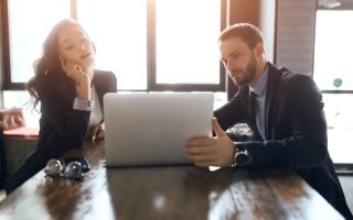 Two employees sharing a laptop