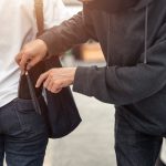 Pickpocket stealing a woman's wallet