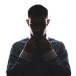 A man alone in the shadows, facing threats and toxic maculinity