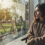 A woman quietly thinking and looking out a window
