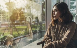 A woman quietly thinking and looking out a window