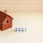 Miniature toy model house with RENT written in blocks