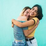 A pair of female friends hugging. Some modern women are cutting off friendships on purpose.