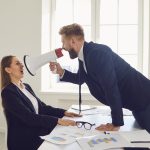 An employee using a megaphone to scream at his boss after deciding to quit