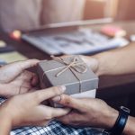 A man receiving a small wrapped present