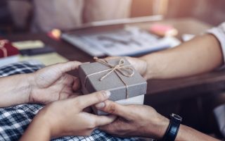 A man receiving a small wrapped present