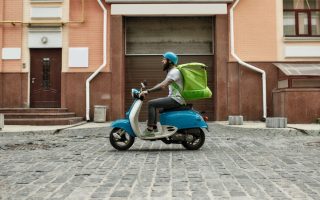 A man driving a scooter doing gig work