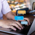 Someone typing on a computer reading the hurtful comments that ruin their self-esteem