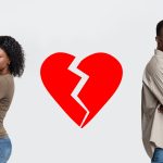 A couple standing back to back with a broken heart in the middle
