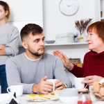 Mother comforting son after discord with wife