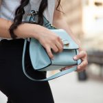 A woman holding a purse, which is an item you should never let a stranger hold