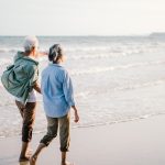 An older couple walking together on the beach