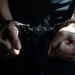 male hands in handcuffs black background