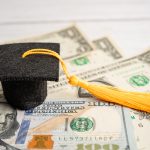 Graduation gap hat on US dollar banknotes money, Education study