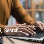 A man using a search engine on his laptop