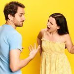 A romantic couple arguing in front of a yellow background