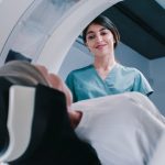 Female doctor looking down a patient in CT scan