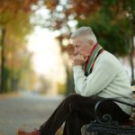 A senior citizen sitting outside on a bench
