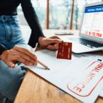 A woman going through overdue bills with a credit card
