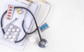 Simple medical background with notebook, stethoscope and pills