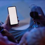 Couple Holding Smartphones while drinking wine