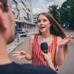 A woman speaking in public on a microphone