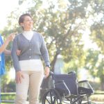 Young caucasian nurse comforting with patient while standing in outdoor park