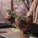 A woman counting money she earned, even though she doesn't feel she deserves it