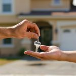 A real estate agent handing over the keys after someone buying a home