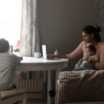 Young single mother with two kids at a kitchen table