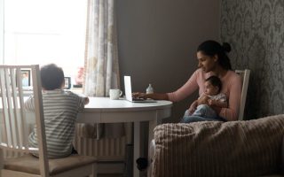 Young single mother with two kids at a kitchen table