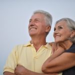 Smiling elderly couple looking out to the sky