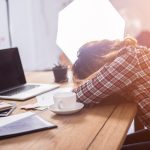Young businesswoman tired at her work desk