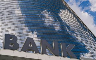A bank sign outside of a tall building