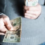 A man handing out a $20 bill