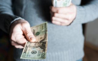 A man handing out a $20 bill